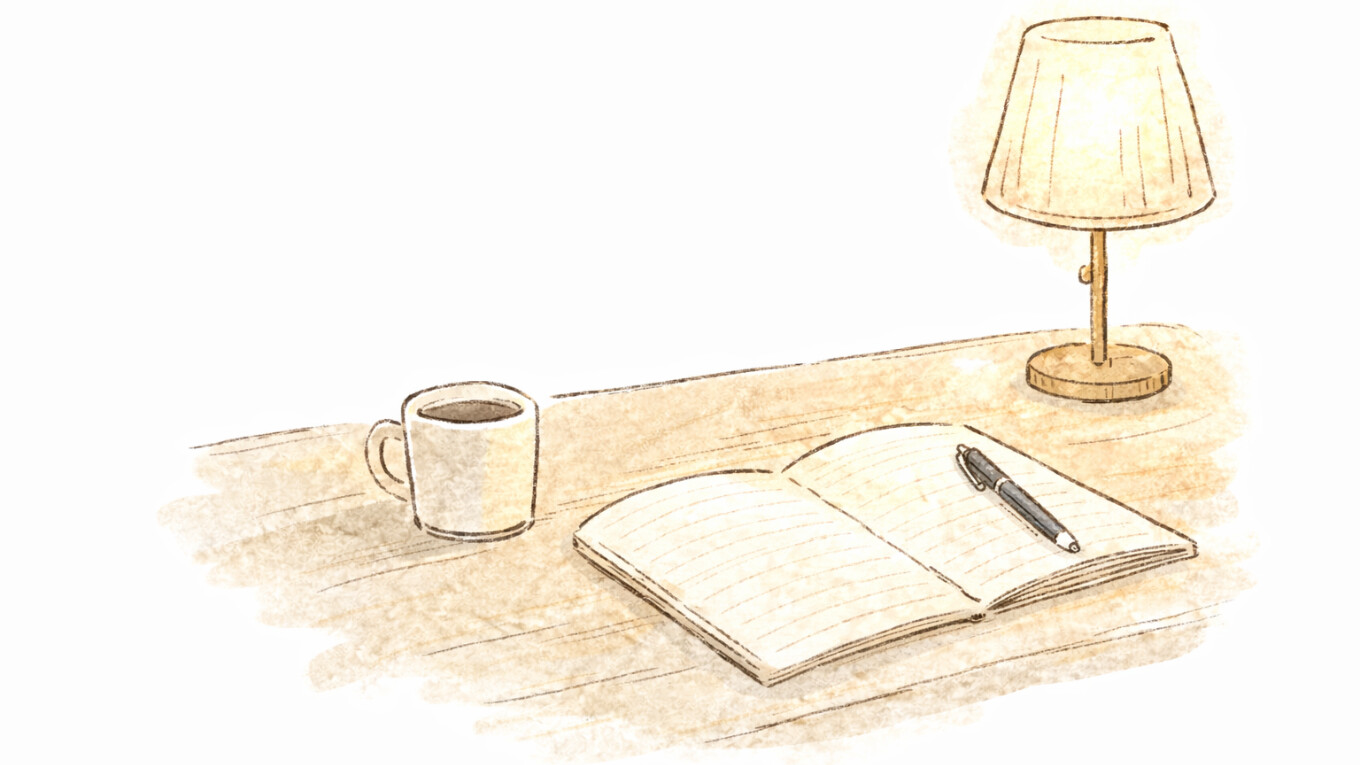 机の上にコーヒーカップと日記帳